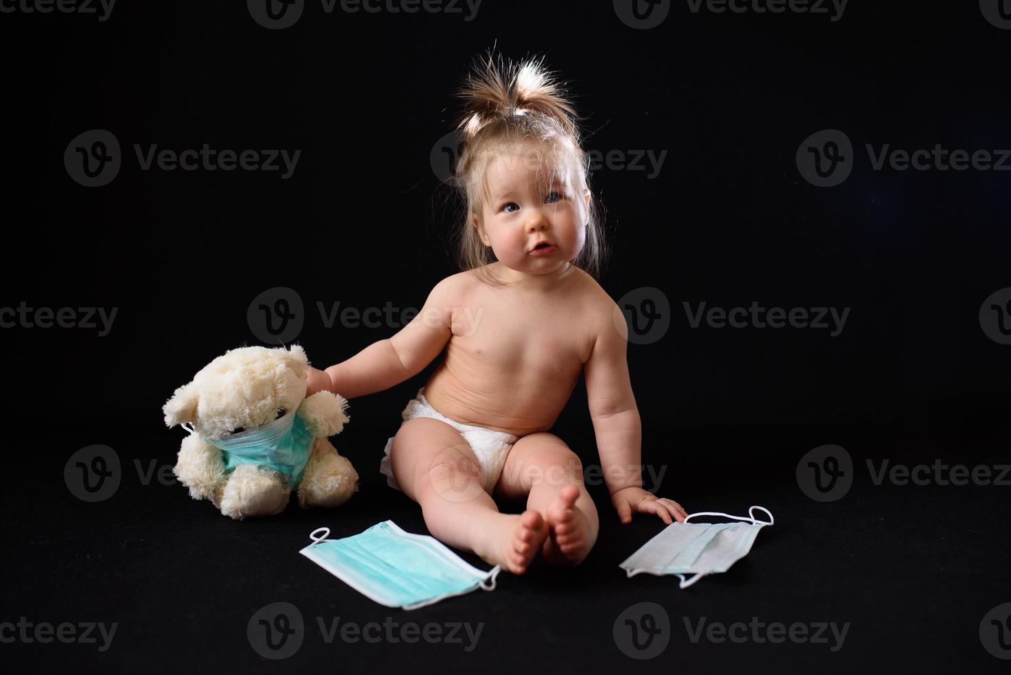 a small child sits next to a sick teddy bear. the concept photo