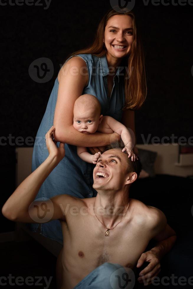 Young parents have fun with their little son photo