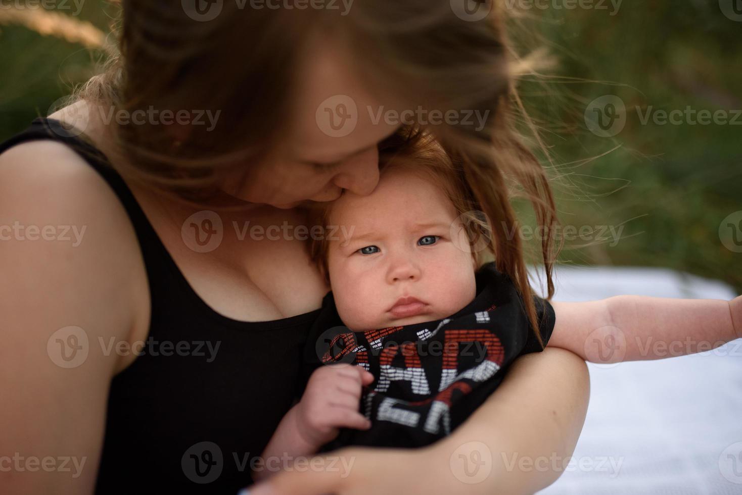 Young mother hugging cute baby outdoor photo