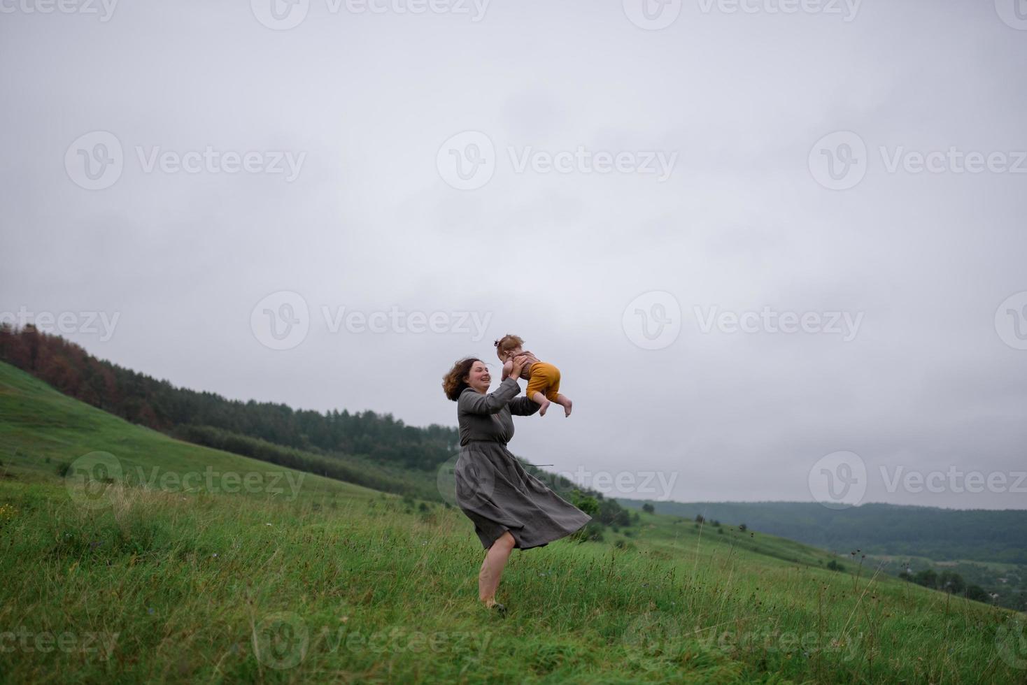 Mom, dad and daughter. Parents Hold baby by hands and go towards the camera. photo