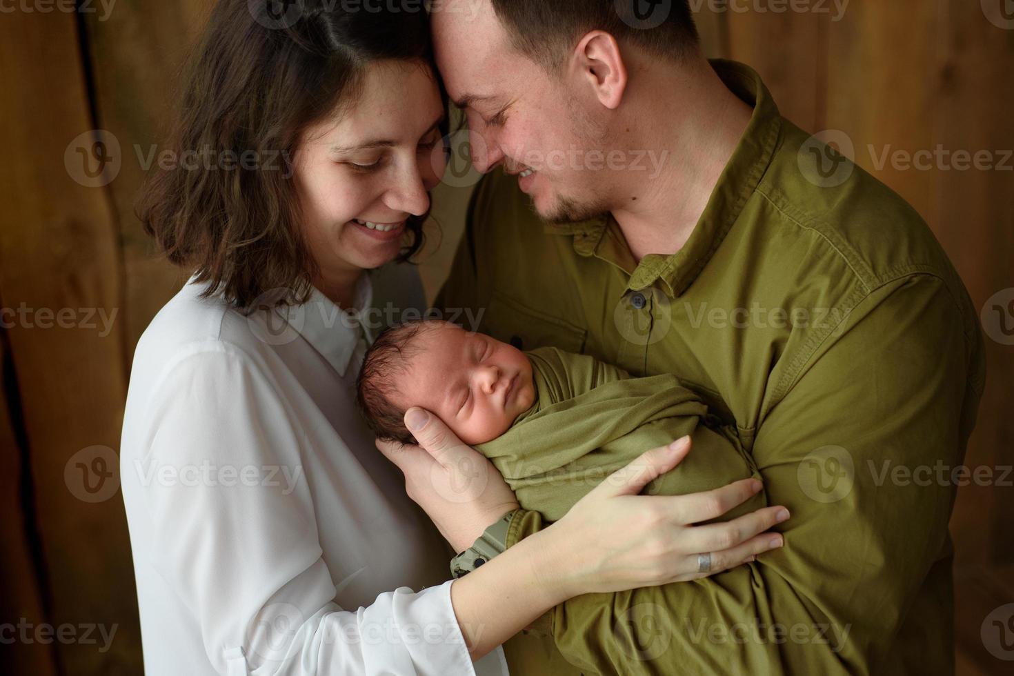 Parents hold their newborn son in their arms photo