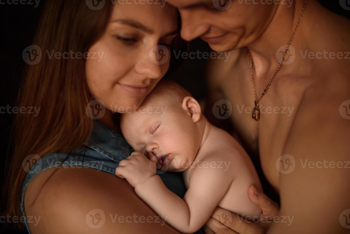 los padres jóvenes se divierten con su pequeño hijo foto