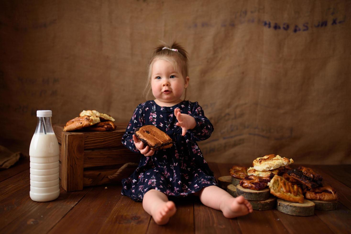 Little girl in the kitchen eats sweet pastries. photo