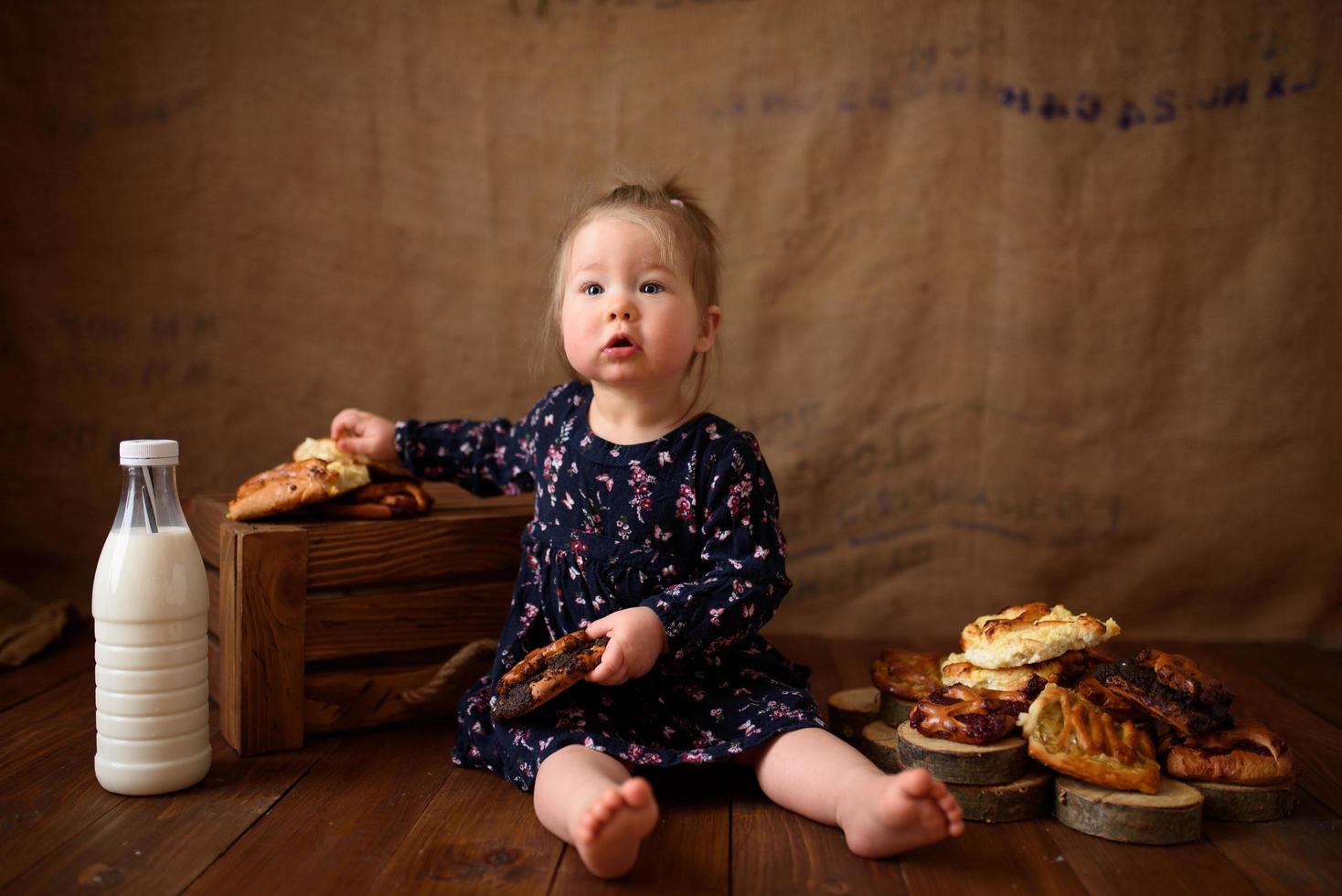 Little girl in the kitchen eats sweet pastries. photo