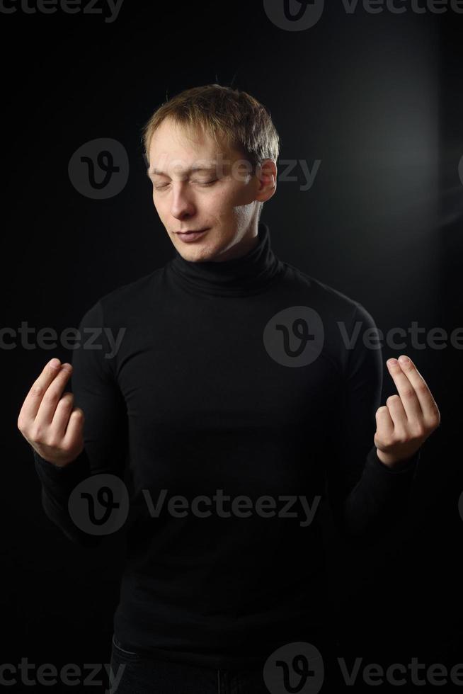 Portrait of determined goodlooking man wearing black shirt, black background. photo