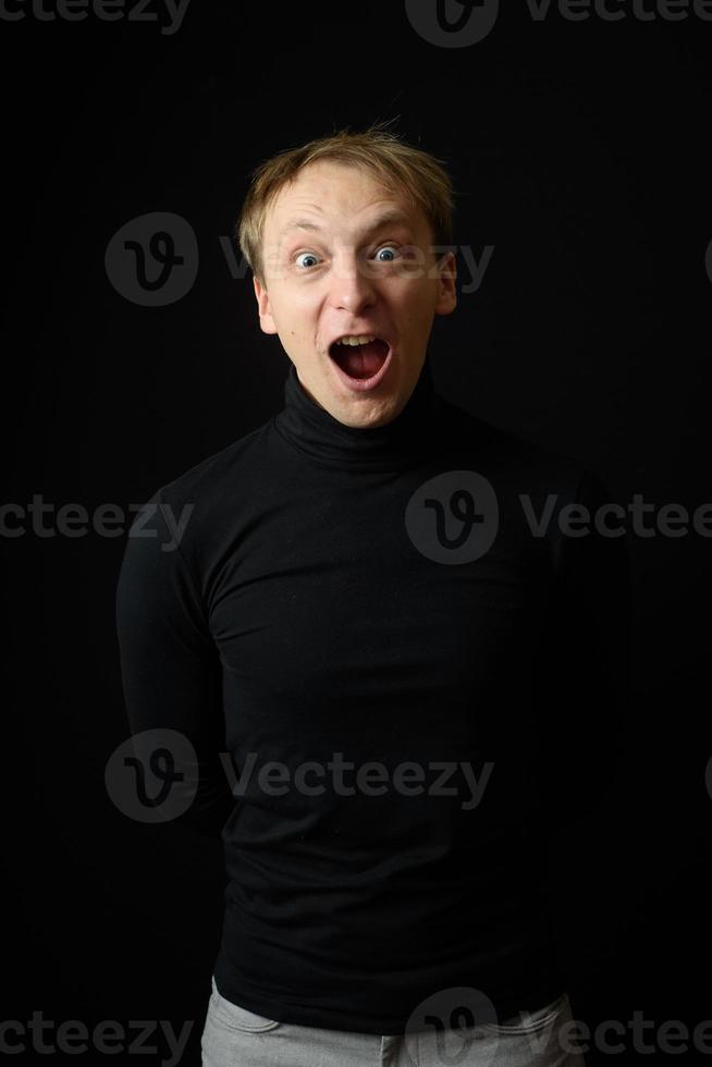 retrato de un hombre apuesto y decidido que usa camisa negra, fondo negro. foto