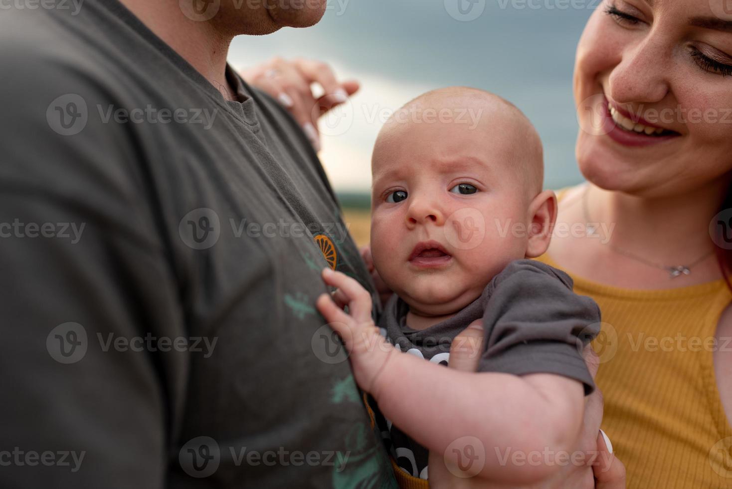 Father, mother and their little son have fun together in a wheat field. photo