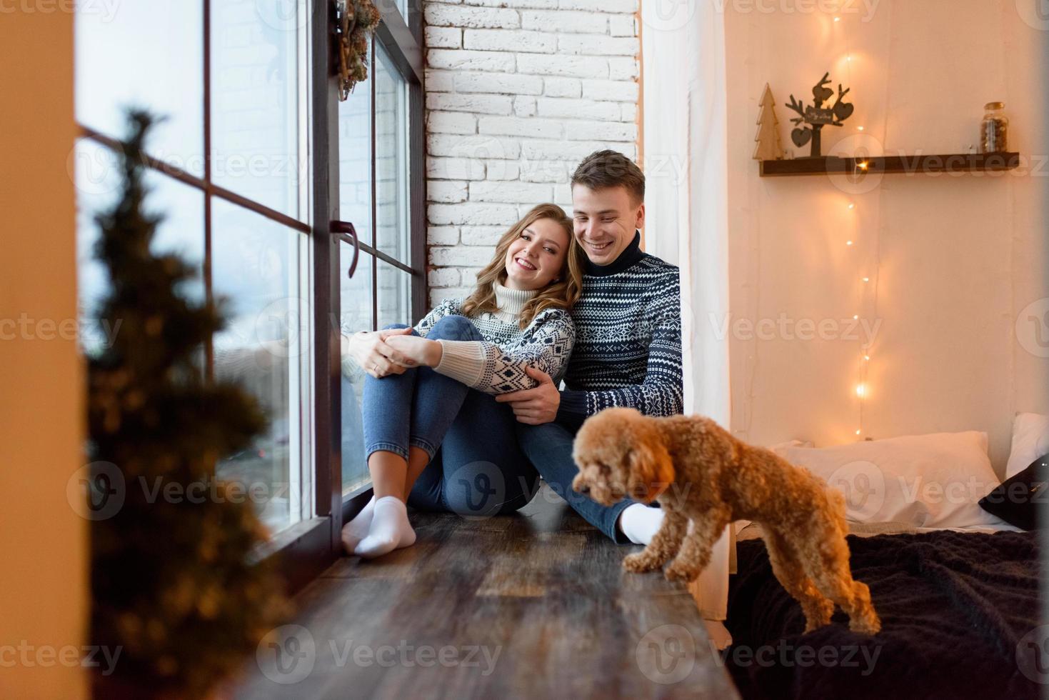 Beautiful couple relaxing at home and loving their pet photo