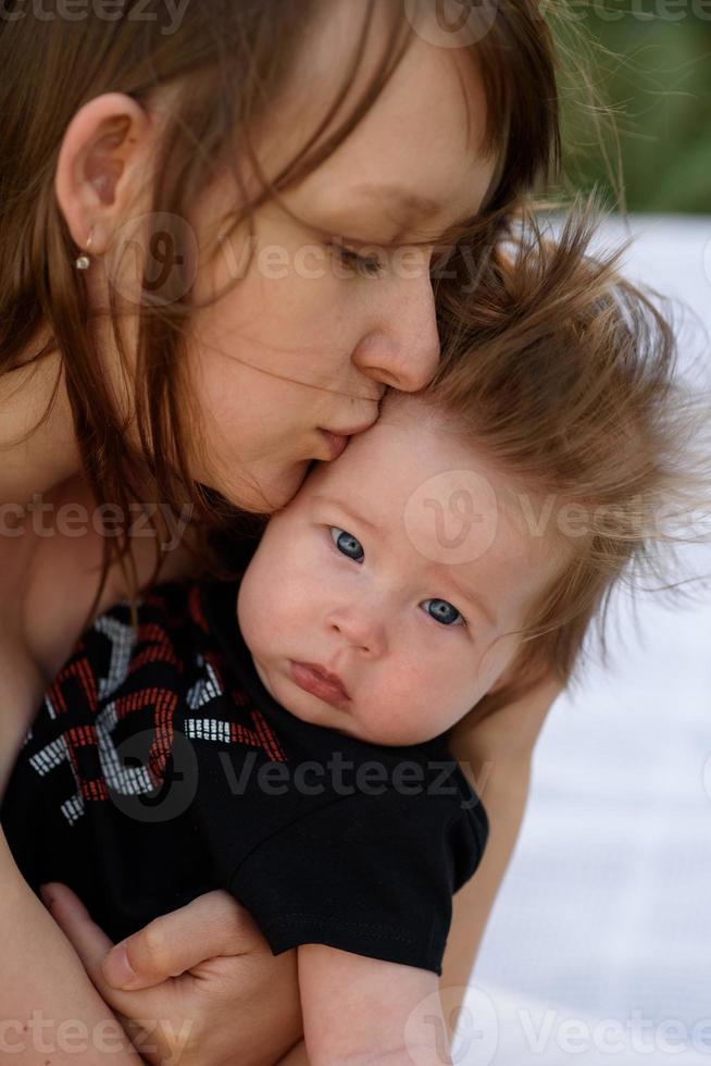 Young mother hugging cute baby outdoor photo