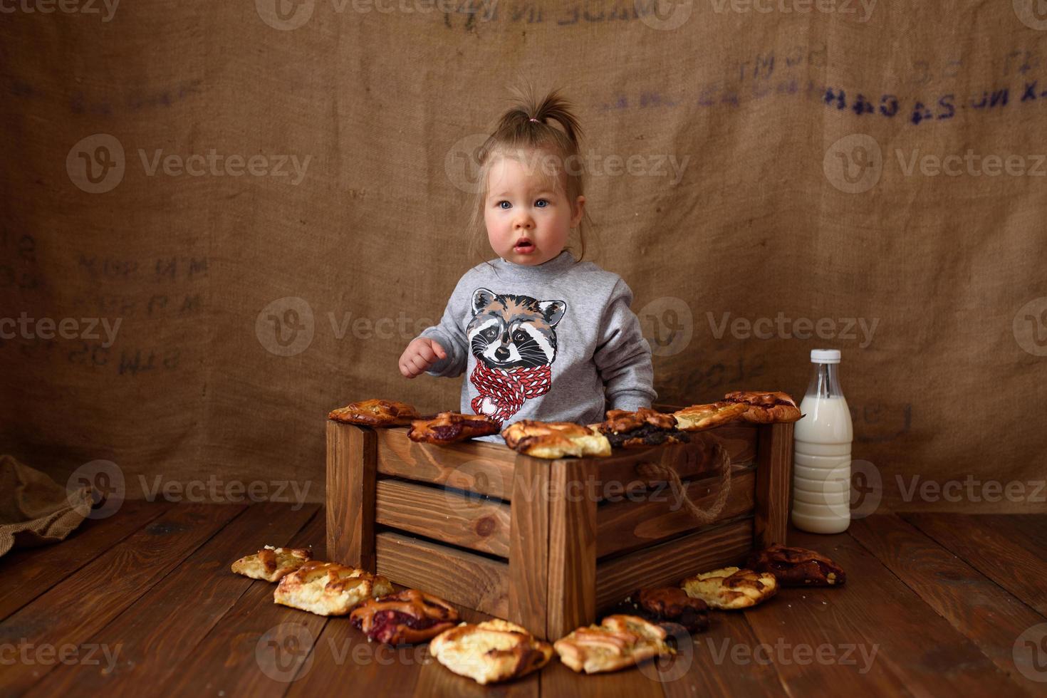 Little girl in the kitchen eats sweet pastries. photo