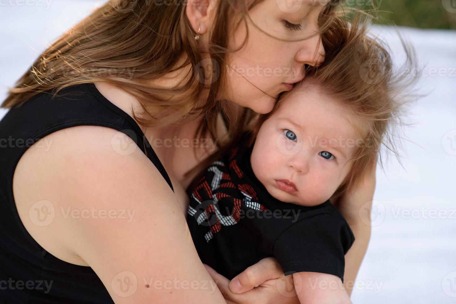 Young mother hugging cute baby outdoor photo