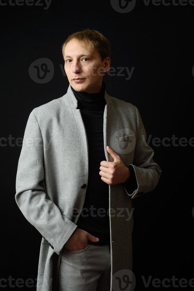 retrato de un hombre apuesto y elegante con un elegante abrigo de otoño foto