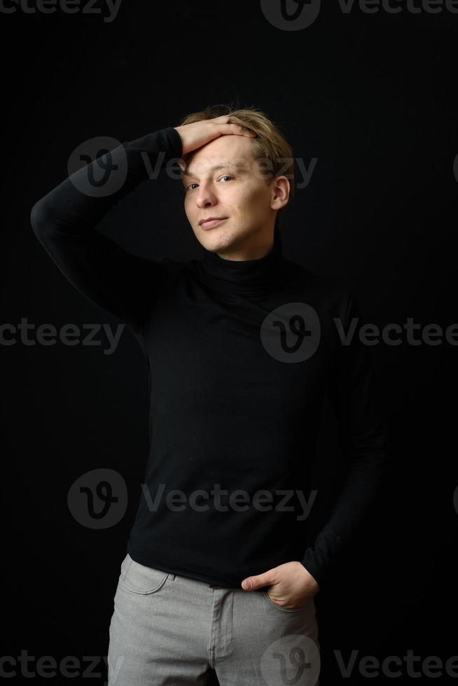 Portrait of determined goodlooking man wearing black shirt, black background. photo