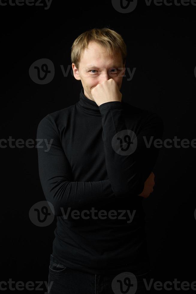 retrato de un hombre apuesto y decidido que usa camisa negra, fondo negro. foto