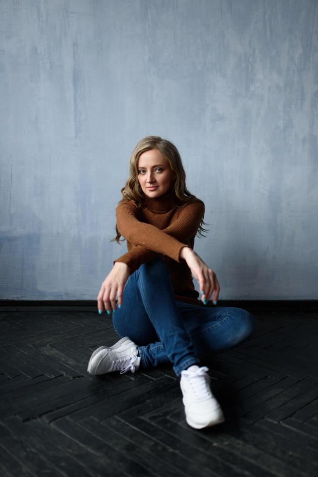 Young beautiful woman with long straight blonde hair in blue jeans photo