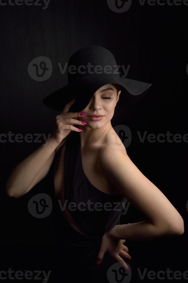 Beautiful woman in hat. Retro fashion. Dark Background. photo