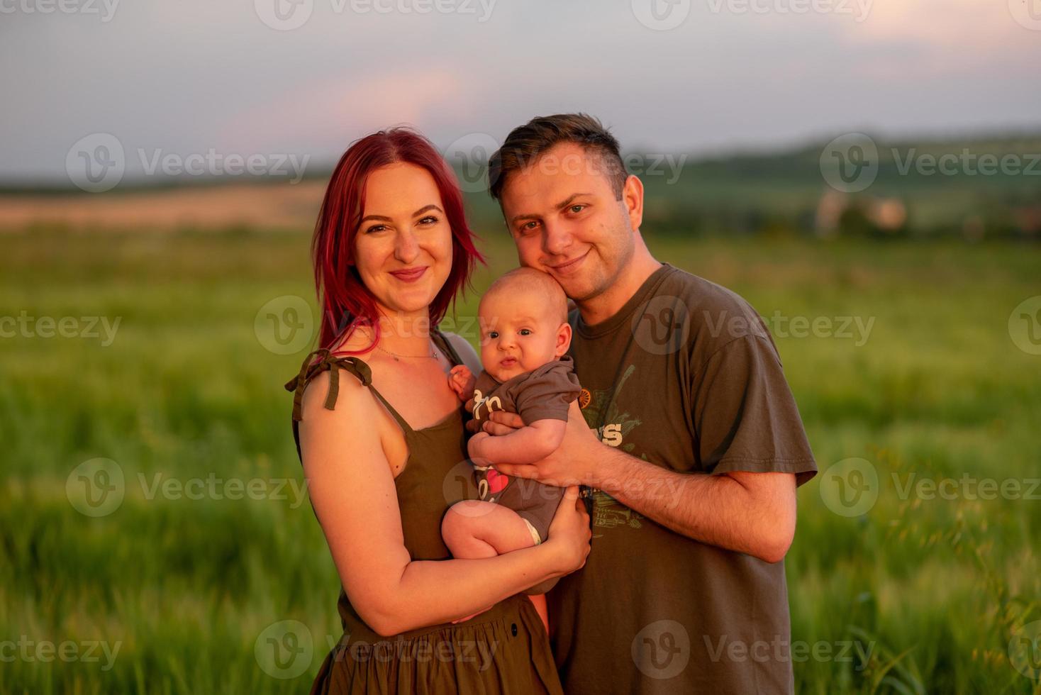 padre, madre y su pequeño hijo se divierten juntos en un campo de trigo. foto