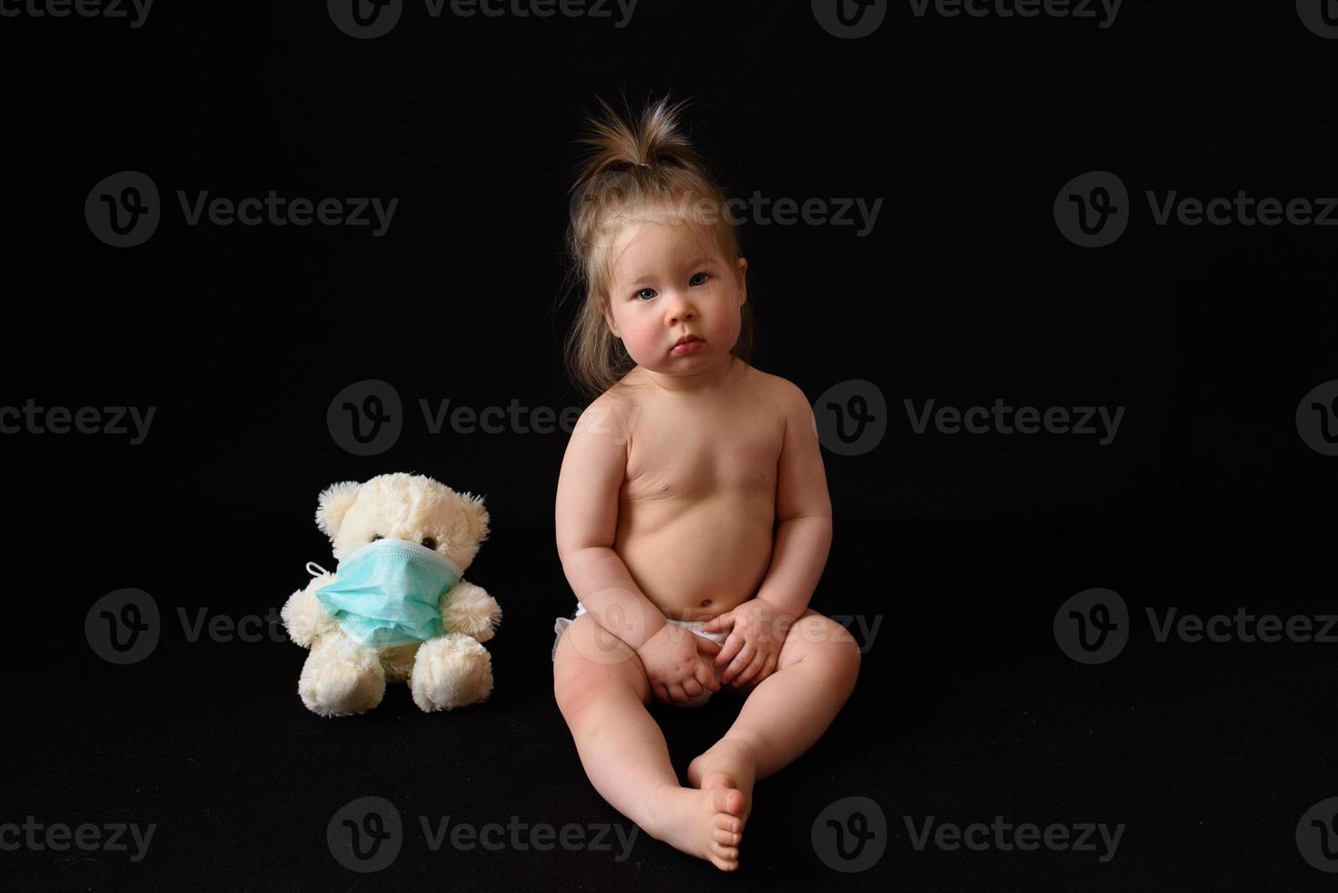 un niño pequeño se sienta al lado de un oso de peluche enfermo. el concepto foto