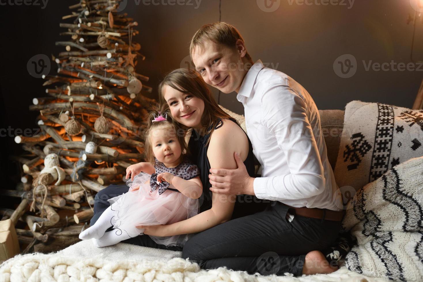 Father mom and their little one year old daughter have fun together before christmas. photo