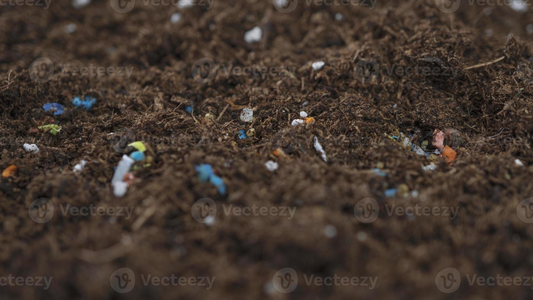 Non-recyclable plastic pollution in the soil. photo