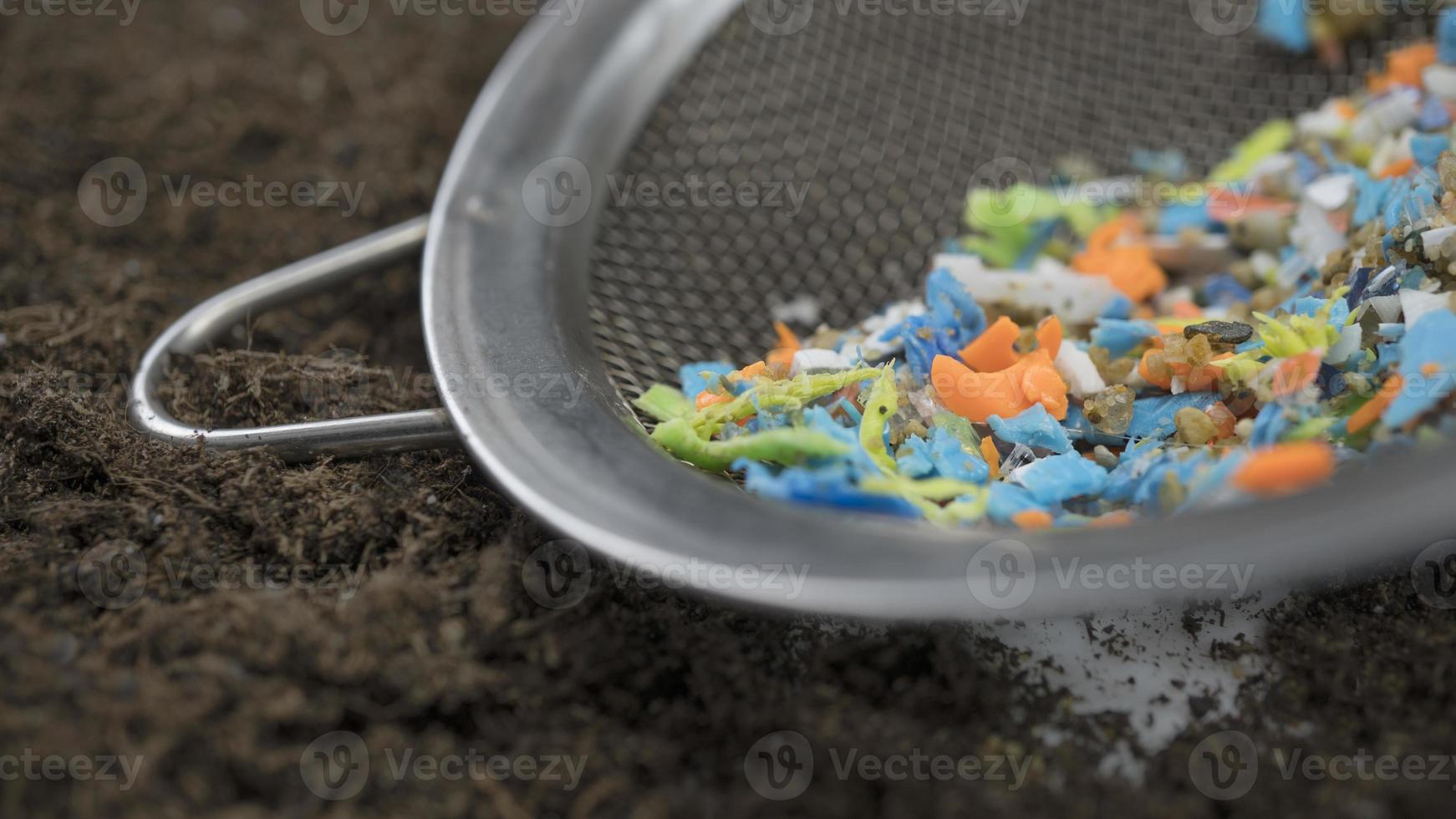 Microplastics hand-picked with a steel sieve from the beach. Non-recyclable plastic pollution in the oceans. photo