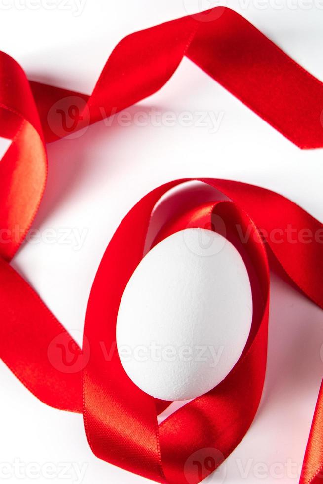 White egg with red silk ribbon. Easter symbol. photo