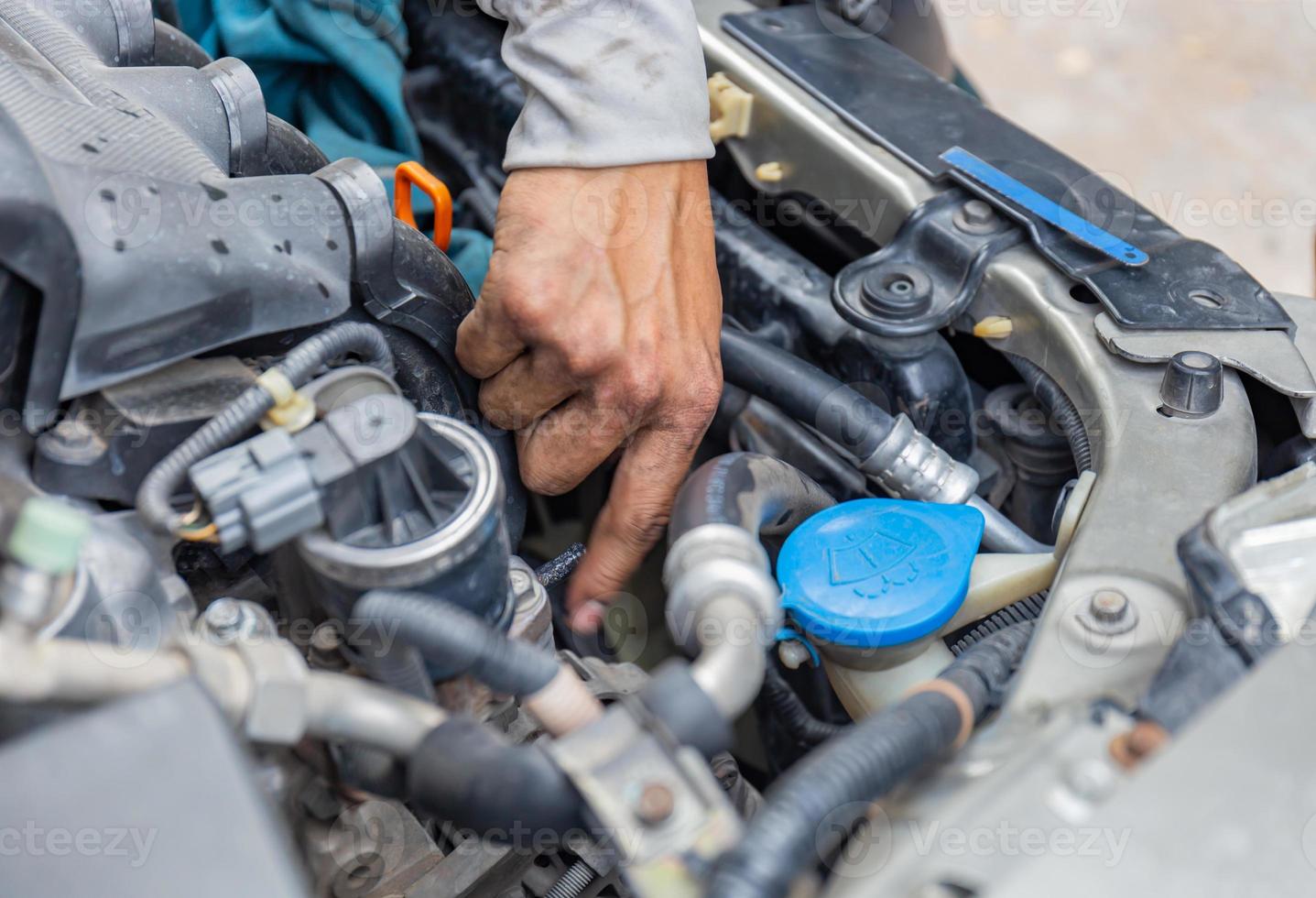 Selective focus of Mechanic fixing cooling water pipe at car