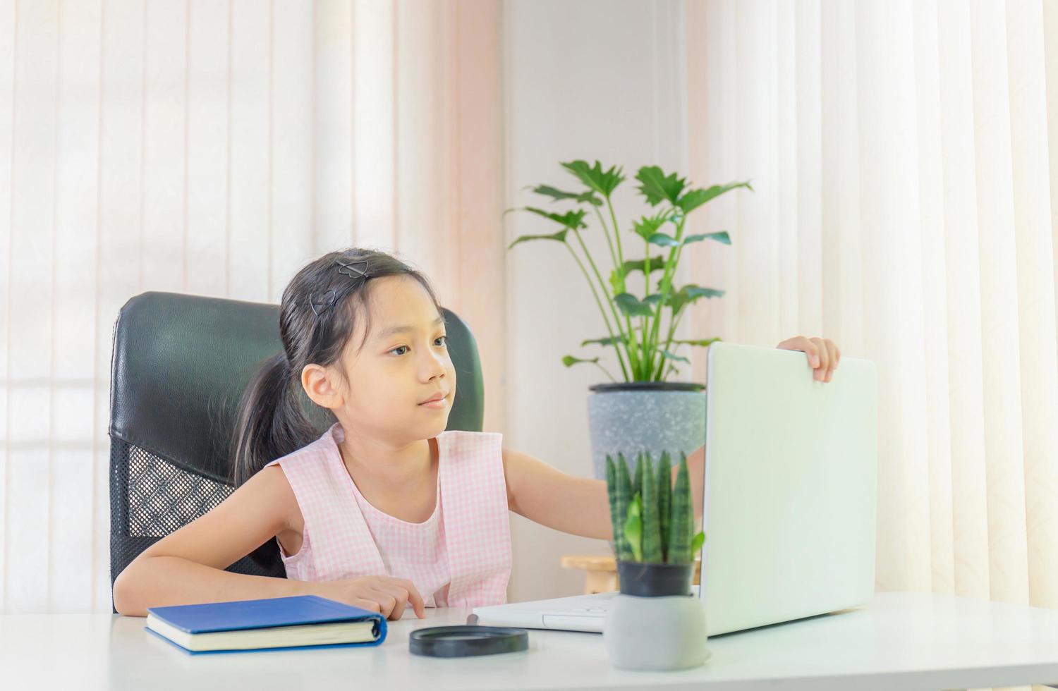 Cheerful little girl smiling and learning online with laptop, Happiness and Learn from home concept photo