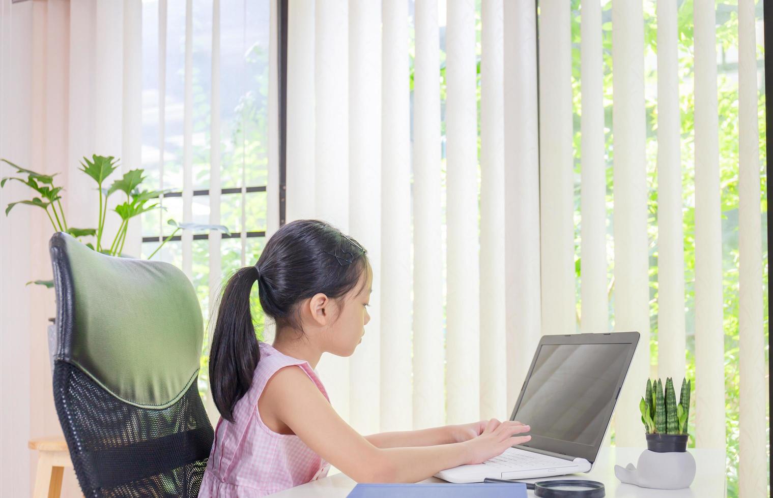 Cheerful little girl smiling and learning online with laptop, Happiness and Learn from home concept photo