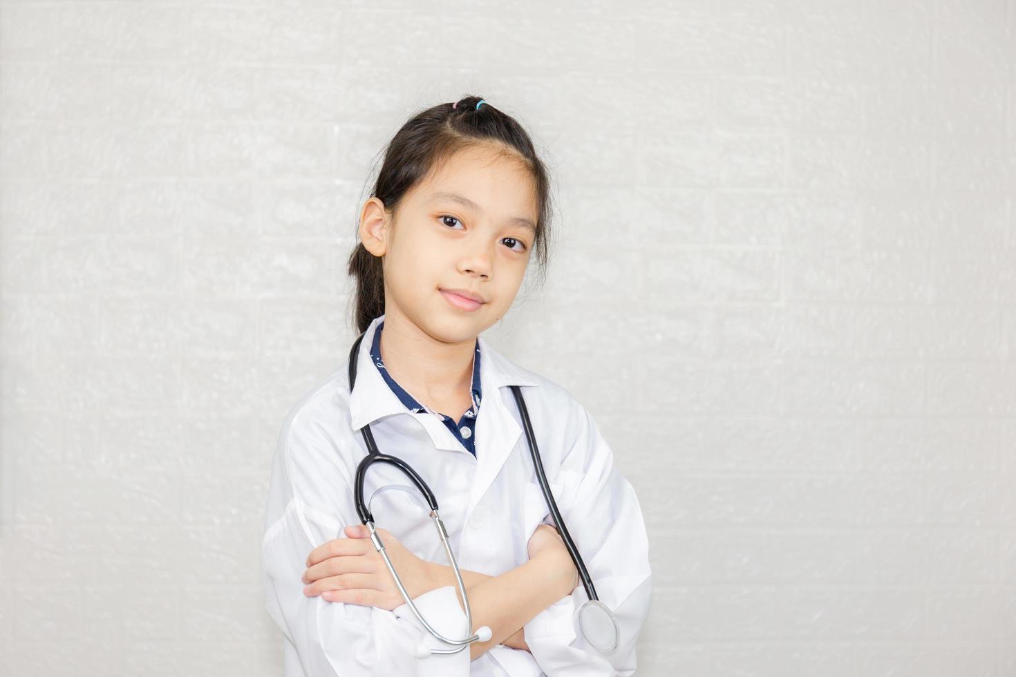 Dream careers concept, Portrait of Happy kid in doctor coat with stethoscope blurred background photo