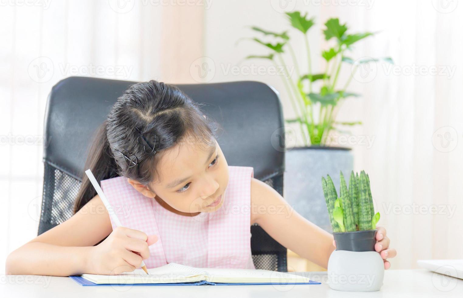 Cheerful little girl looking a potted plant and drawing a picture, Happiness and Learn from home concept photo