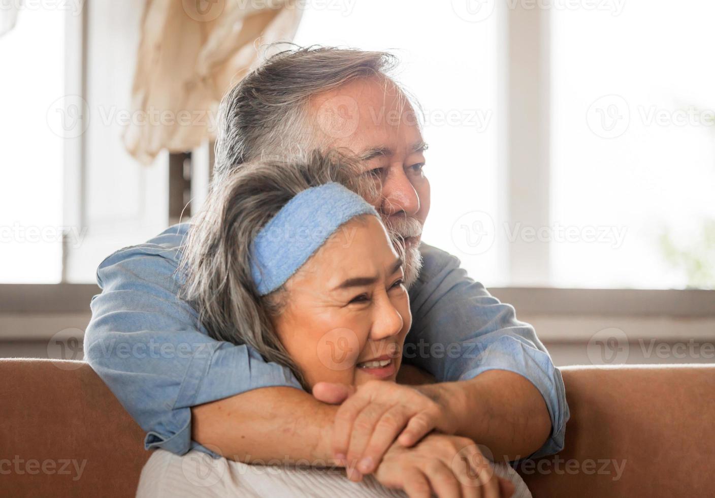 Close up portrait of happy senior asian couple hugging in living room photo