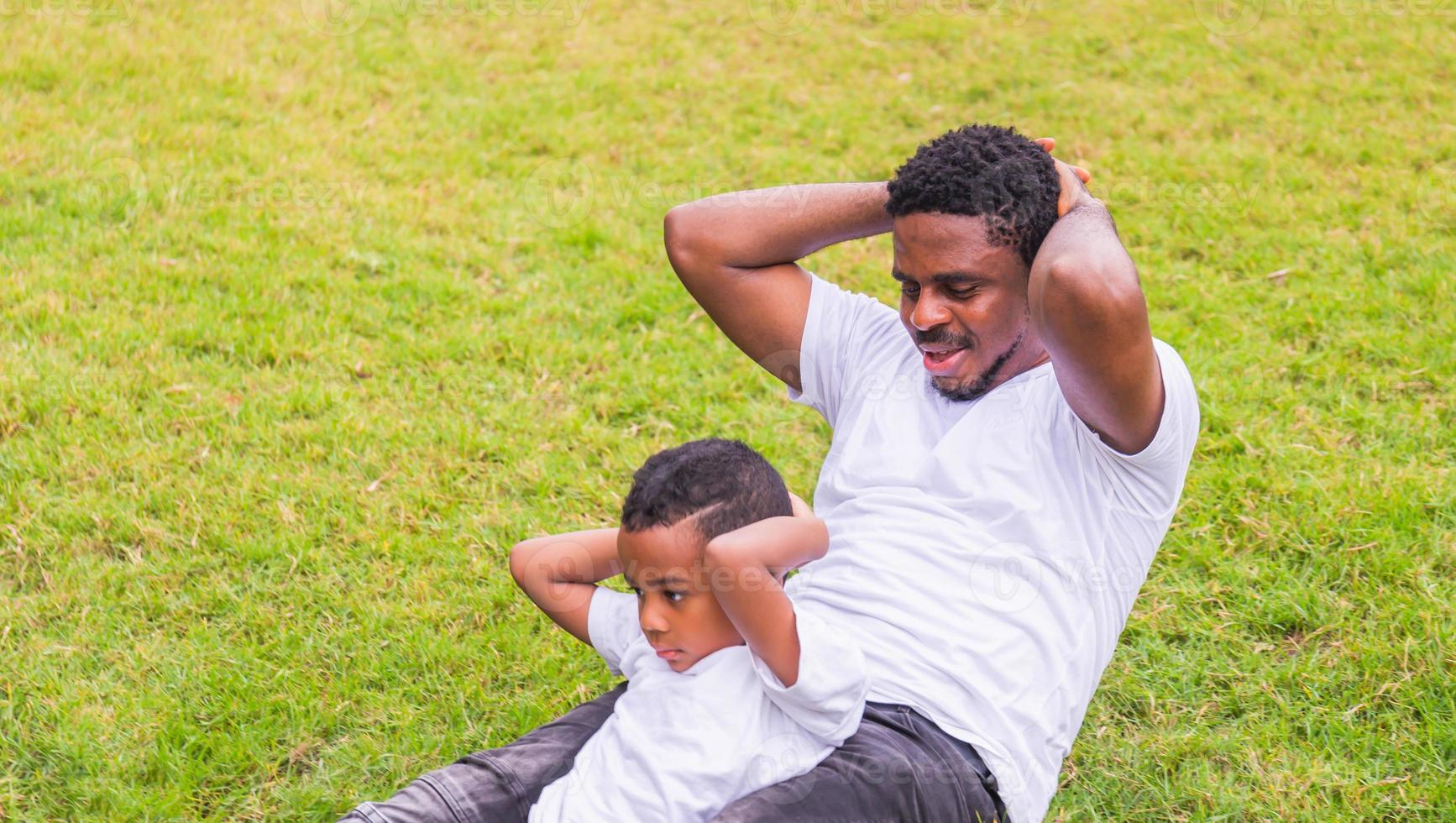 Cheerful african american father and son playing exercising in the park, Happiness family concepts photo