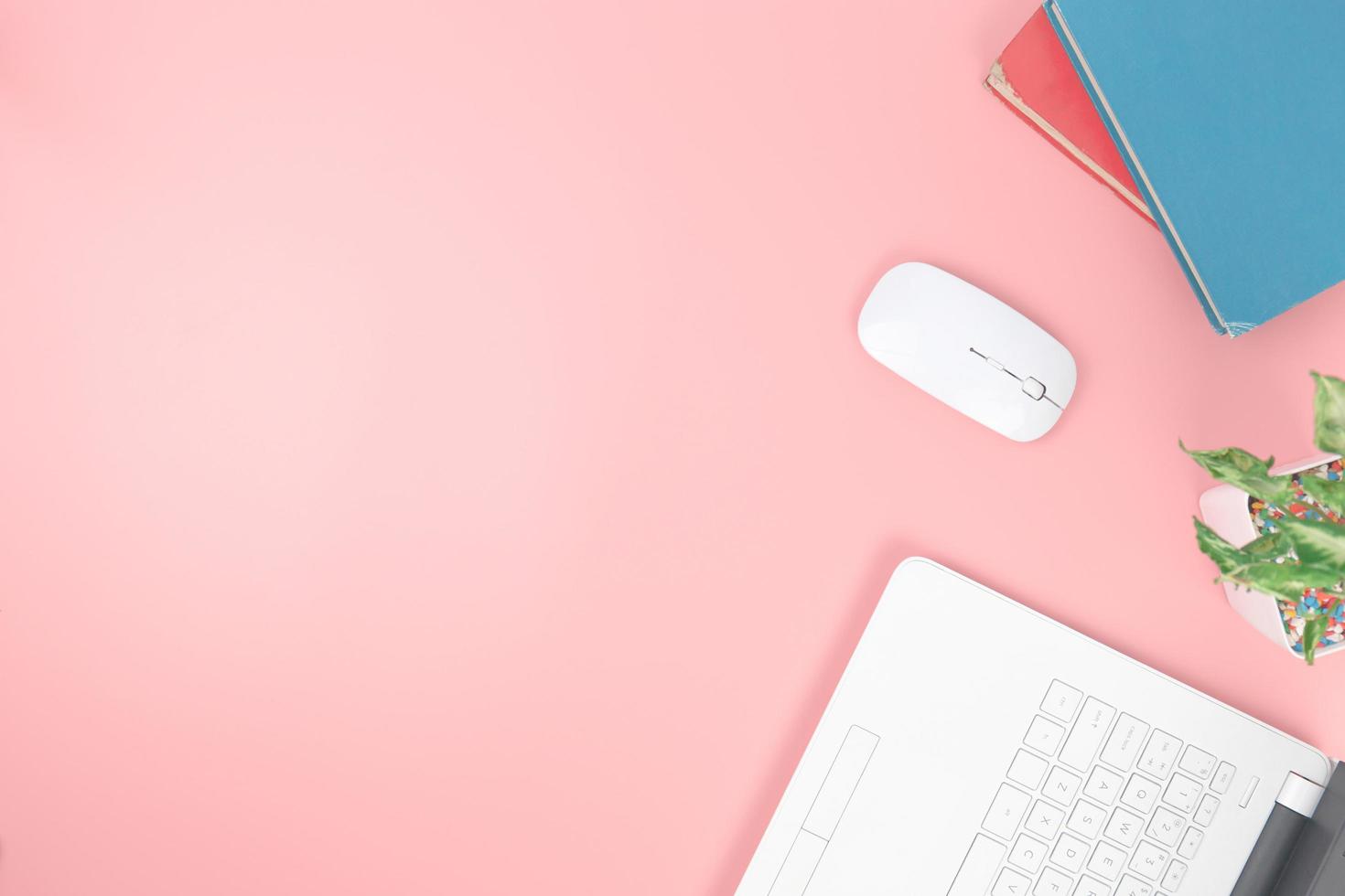 Top view with copy space of Laptop notebook and books overhead on pink pastel background, Flat lay concept photo