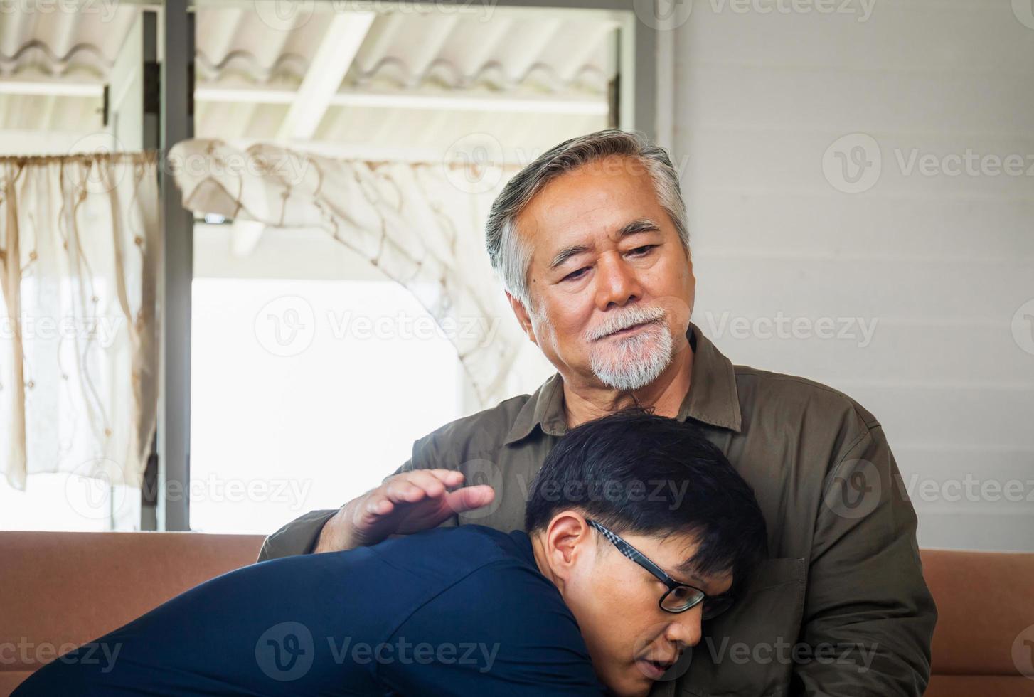 padre asiático mayor da consejos a un hijo adulto en la sala de estar, conceptos familiares de felicidad foto