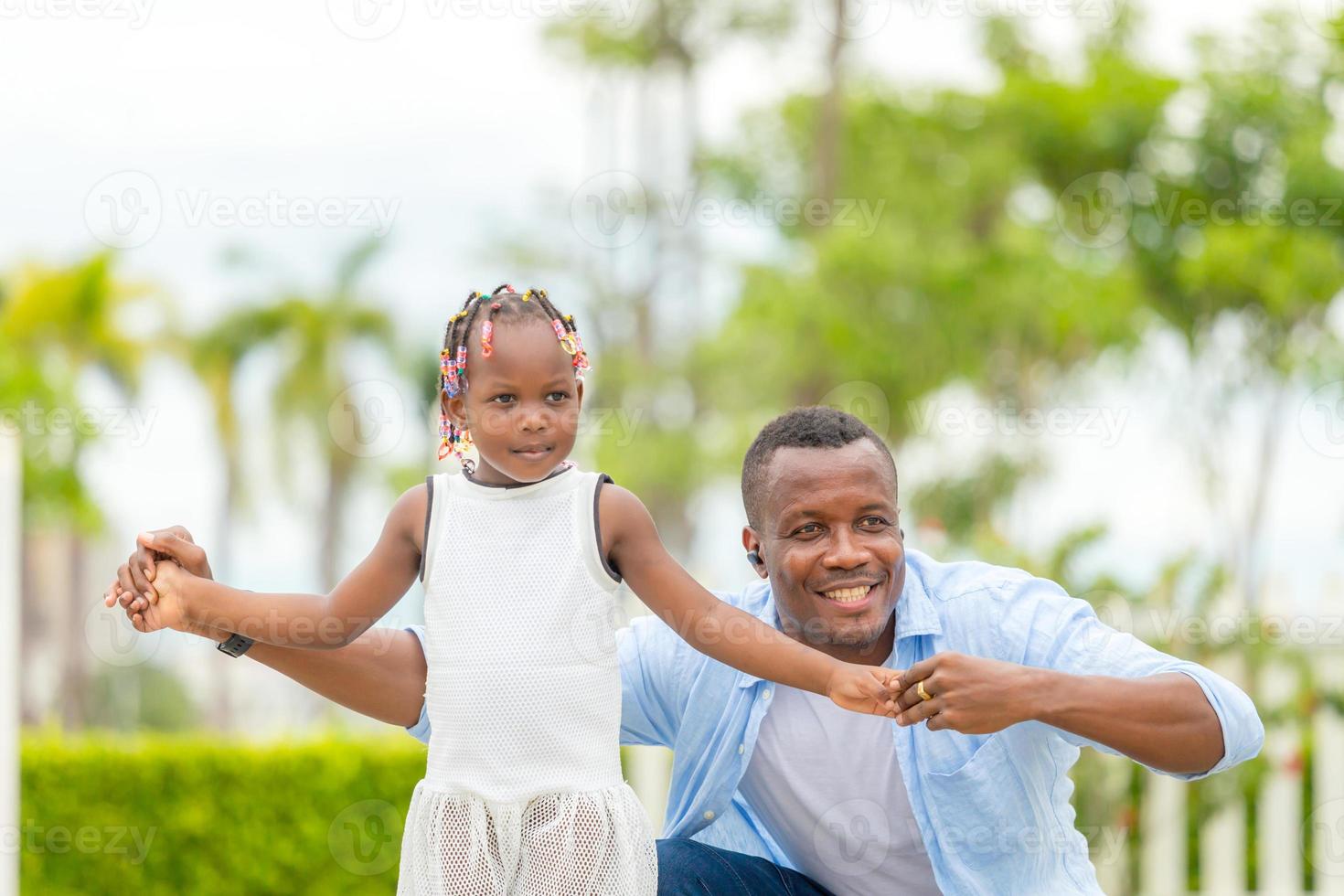 Happy father playing with daughter, Cheerful african american girl playing with her father photo