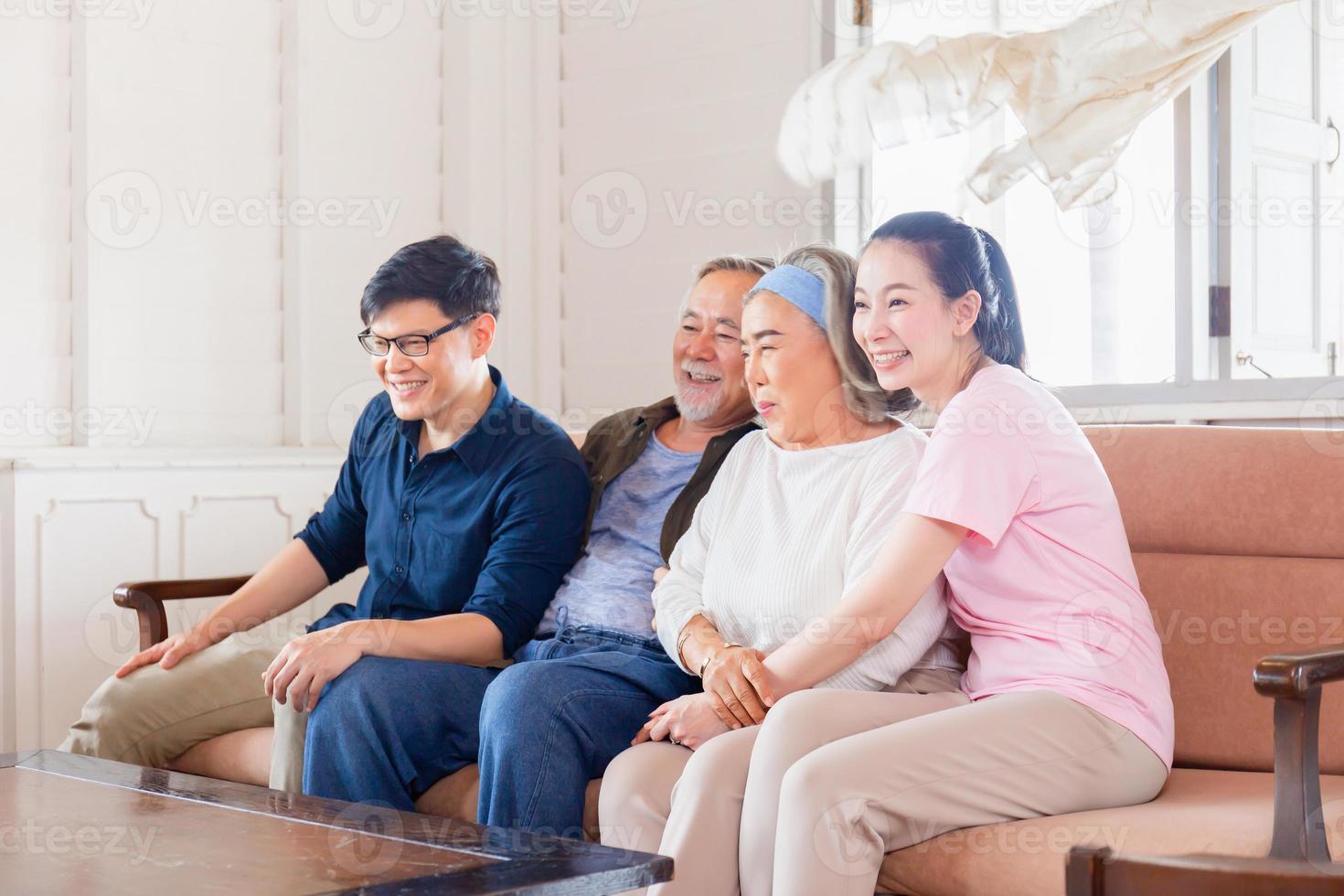 Daughter senior mother father and middle aged son sitting on sofa, Cheerful Asian family watching television in living room, Happiness family concepts photo