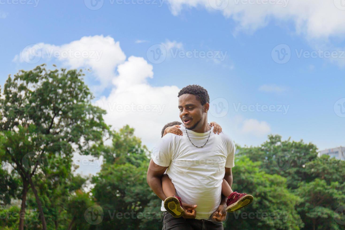 Cheerful african american father and two sons playing in park, Happiness family concepts, parent and childs play in park photo