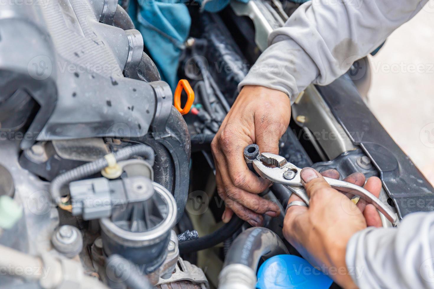 abrazadera de manguera de fijación mecánica con alicates herramienta tubería de agua de refrigeración en el motor del automóvil, concepto de reparación de automóviles foto