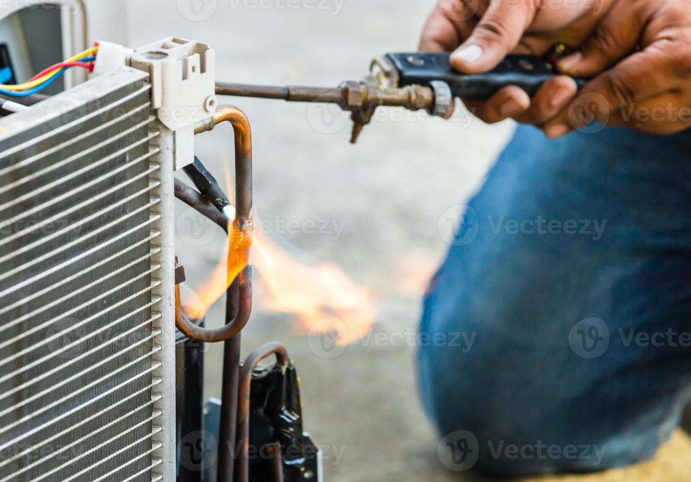 Close up of Air Conditioning Repair use fuel gases and oxygen to weld or cut metals, Oxy-fuel welding and oxy-fuel cutting processes, repairman on the floor fixing air conditioning system photo