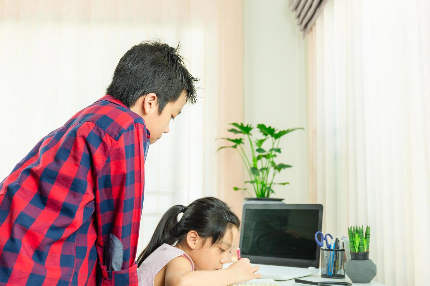 Brother looking sister drawing a picture, Learn from home concept photo
