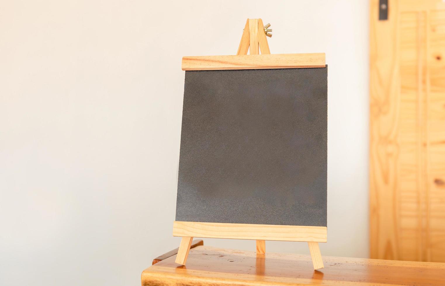 Blank chalkboard photo frames display on the wooden table in coffee shop for your design