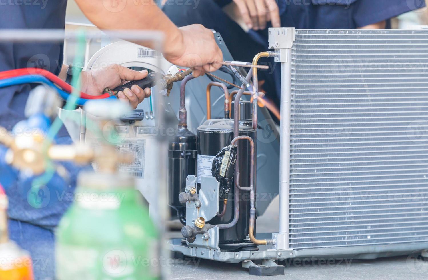 Close up of Air Conditioning Repair team use fuel gases and oxygen to weld or cut metals, Oxy-fuel welding and oxy-fuel cutting processes, repairman on the floor fixing air conditioning system photo