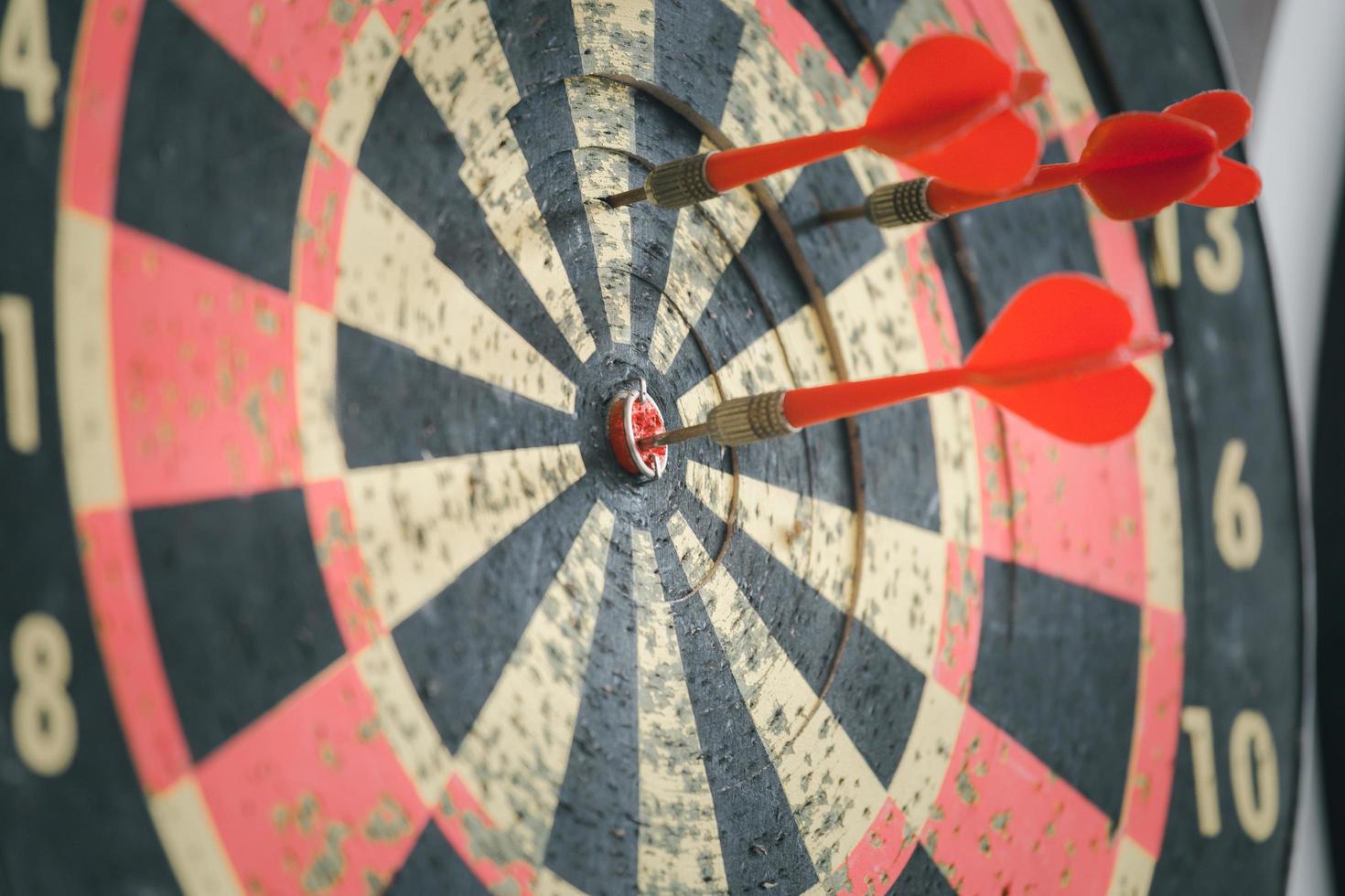 Red dart arrow hit on the old dartboard, Business target and goal concept photo