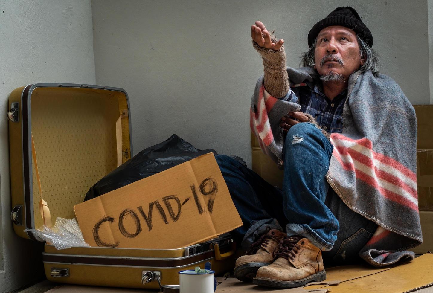 el hombre sin hogar pide ayuda a los transeúntes ya que no tiene hogar ni trabajo debido a la epidemia de covid 19. foto