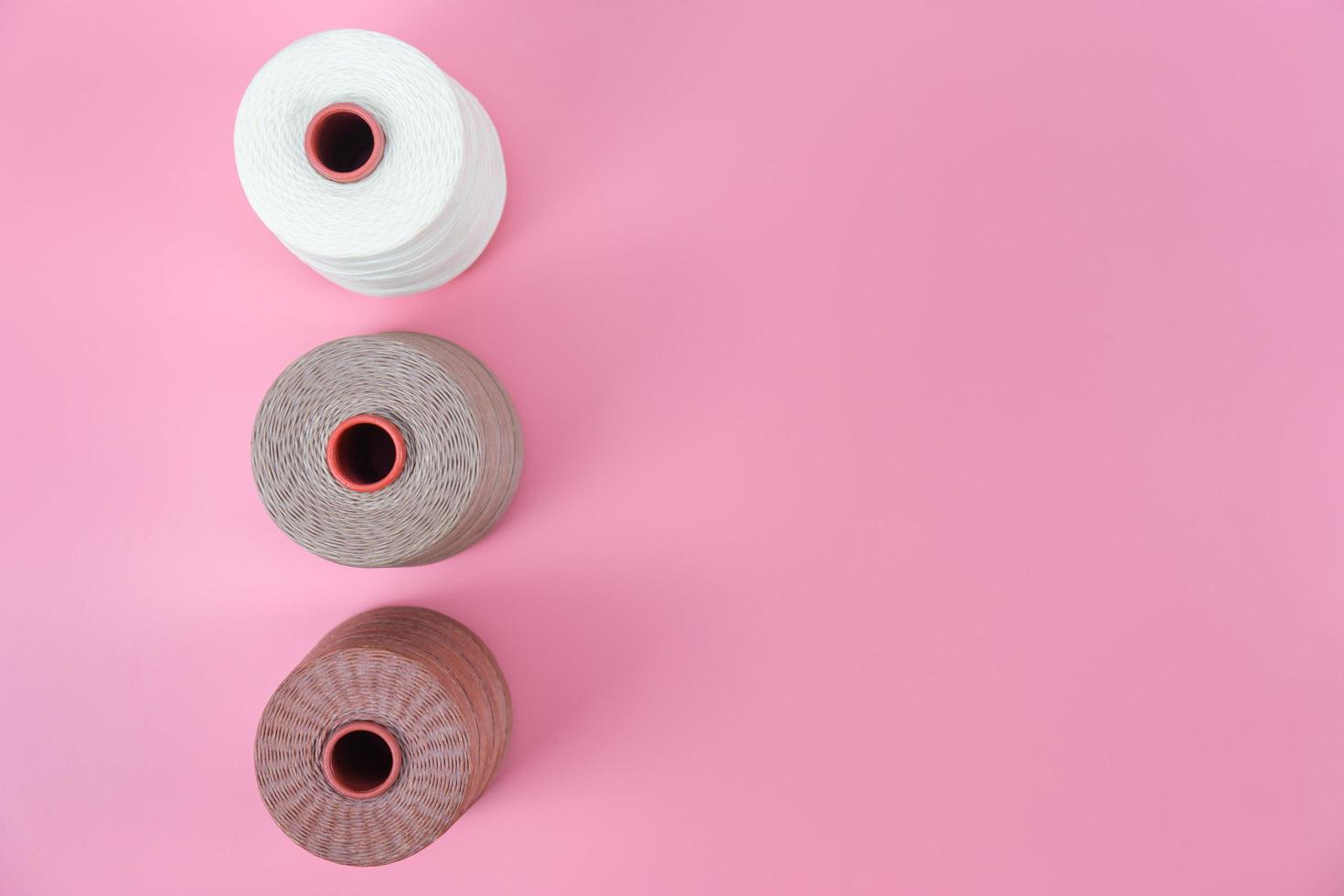 Top view with copy space of Waxed rope group white and brown color overhead on pink pastel background, Leather craft or leather working flat lay concept photo