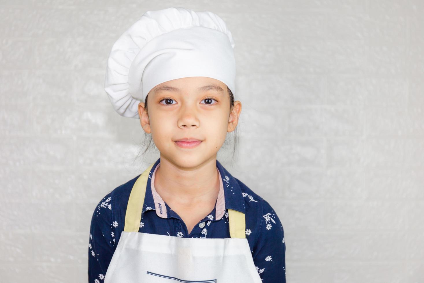 concepto de carreras de ensueño, retrato de niño feliz chef mirando la cámara con fondo borroso foto