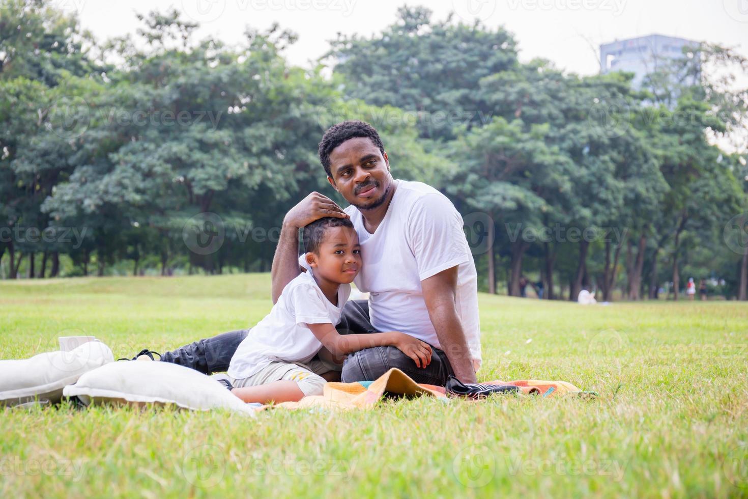 alegre padre afroamericano e hijo jugando en el parque, conceptos familiares de felicidad, padres e hijos juegan en el parque foto