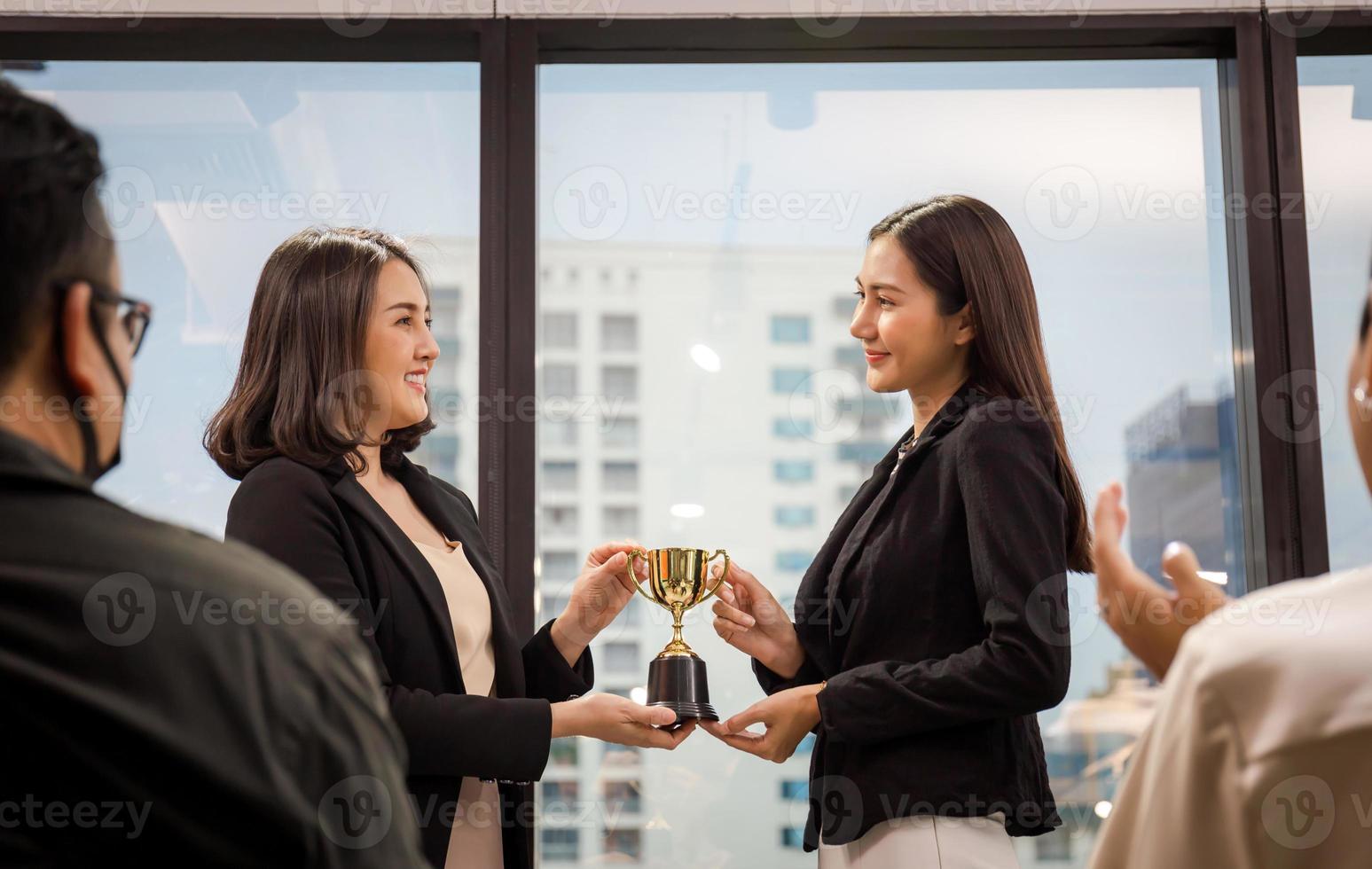 equipo de negocios exitoso con trofeo de premio en la sala de reuniones, equipo de negocios ganador con un premio de trofeo de oro, concepto de éxito y trabajo en equipo foto