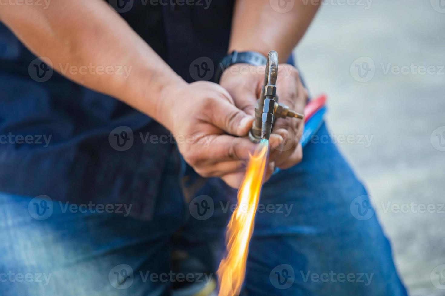 Air conditioning repair man use fuel gases and oxygen to weld or cut metals, Oxy-fuel welding and oxy-fuel cutting processes, repairman on the floor fixing air conditioning system photo